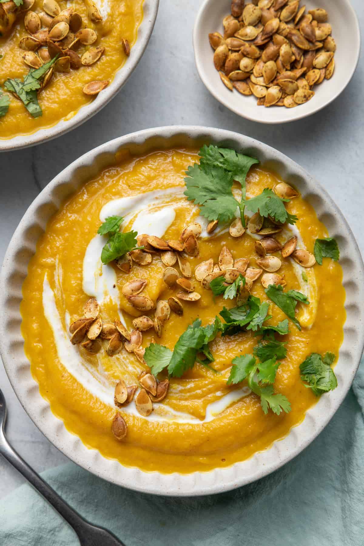 Acorn squash soup garnished with whole milk yogurt, toasted seeds and cilantro