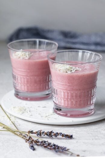 Two glasses of aloe vera smoothie topped with shredded coconut