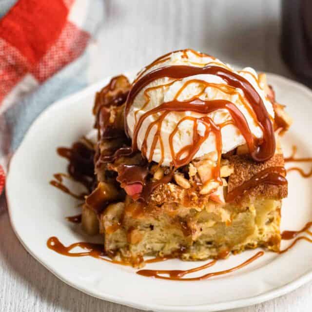 Plate of the apple bread pudding with ice cream on top and caramel sauce drizzle over