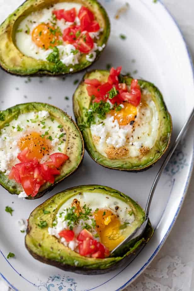 Taking a spoonful of the baked eggs in avocado