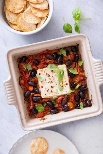 Baked feta dip served with crackers in a bowl on the side