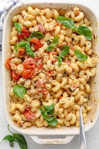 Baking dish of baked feta pasta with spoon inside for serving