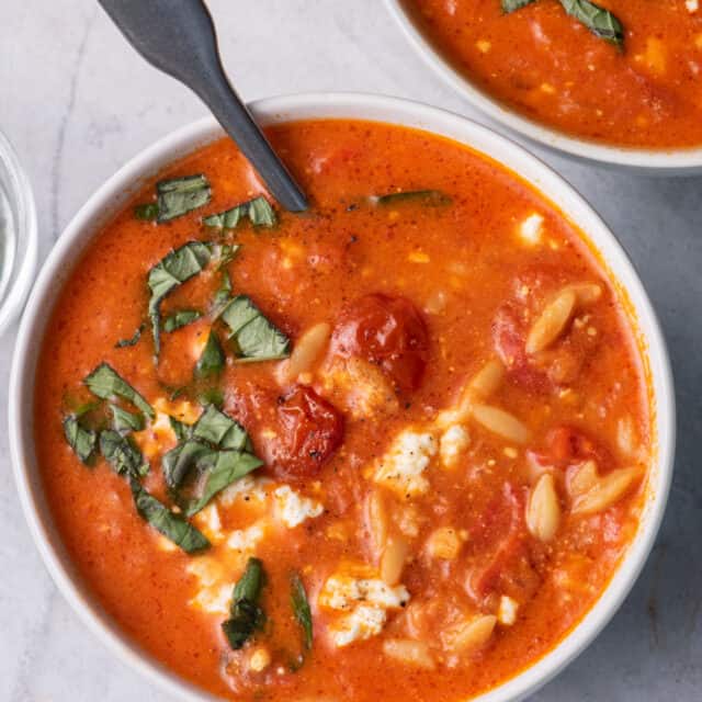 Large bowl of baked feta soup with spoon inside