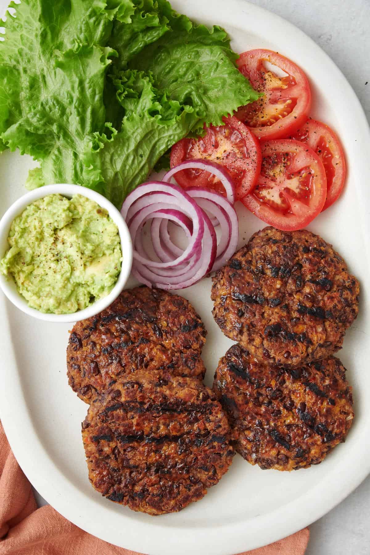 Final recipe showing the salsa black bean burger in a bun with condiments next to potato chips