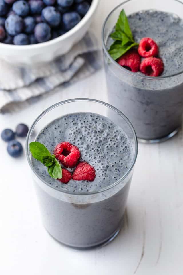 Blueberry banana smoothie topped with raspberries and mint