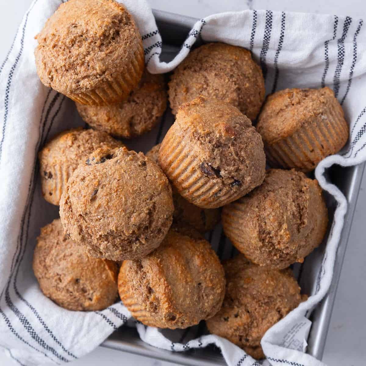 Bran muffins in a cloth lined pan.