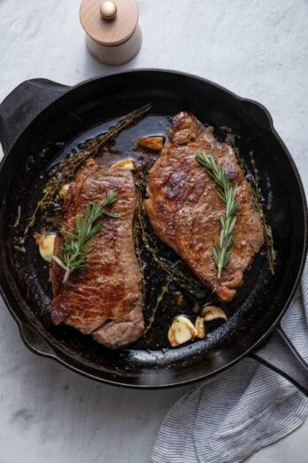 Steak cooked in cast iron skillet with rosemary and garlic