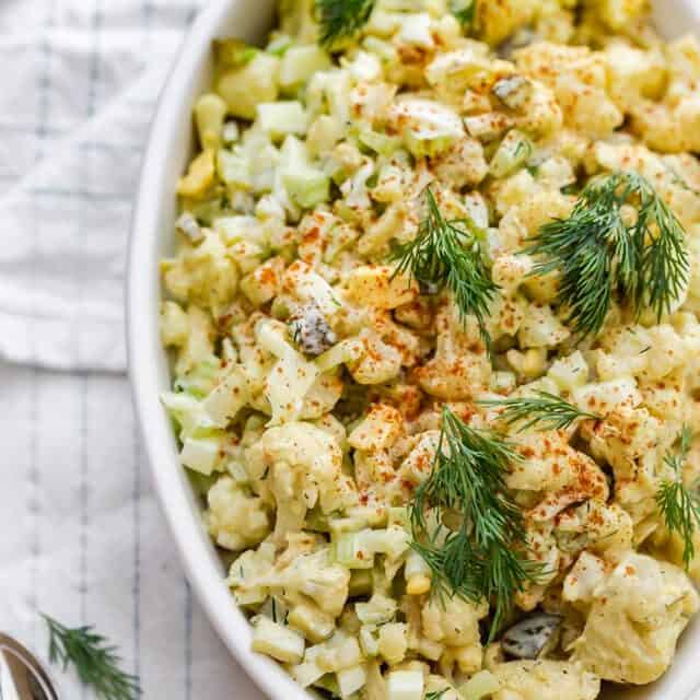 Final cauliflower potato salad garnished with dill and paprika