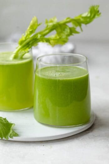 Two glass cups of fresh celery juice made in a juicer