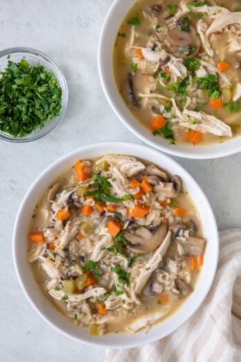 2 bowls of soup garnished with fresh parsley.