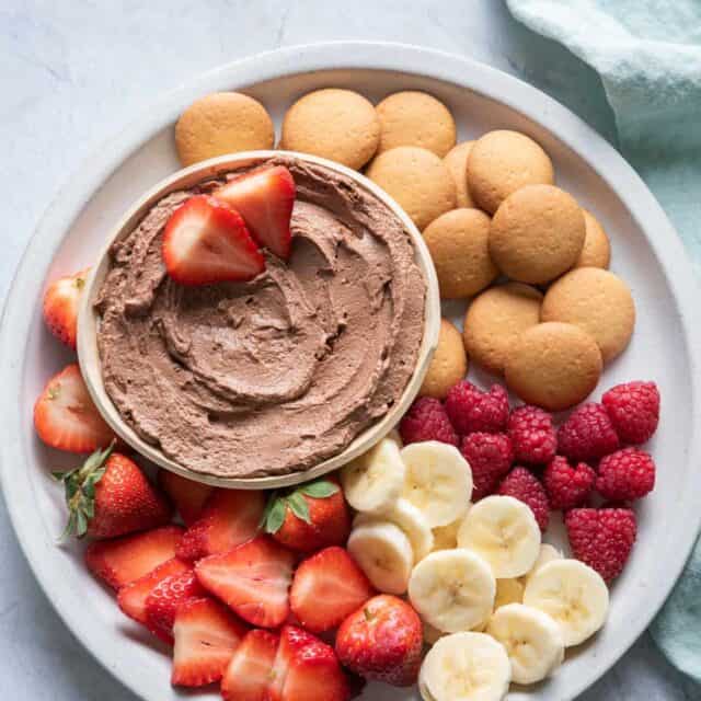 Chocolate Peanut Butter Dip on a plate with fruit and wafers for dippings