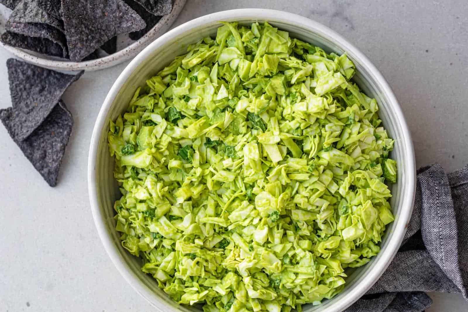 Bowl of green goddess salad served with tortilla chips on the side