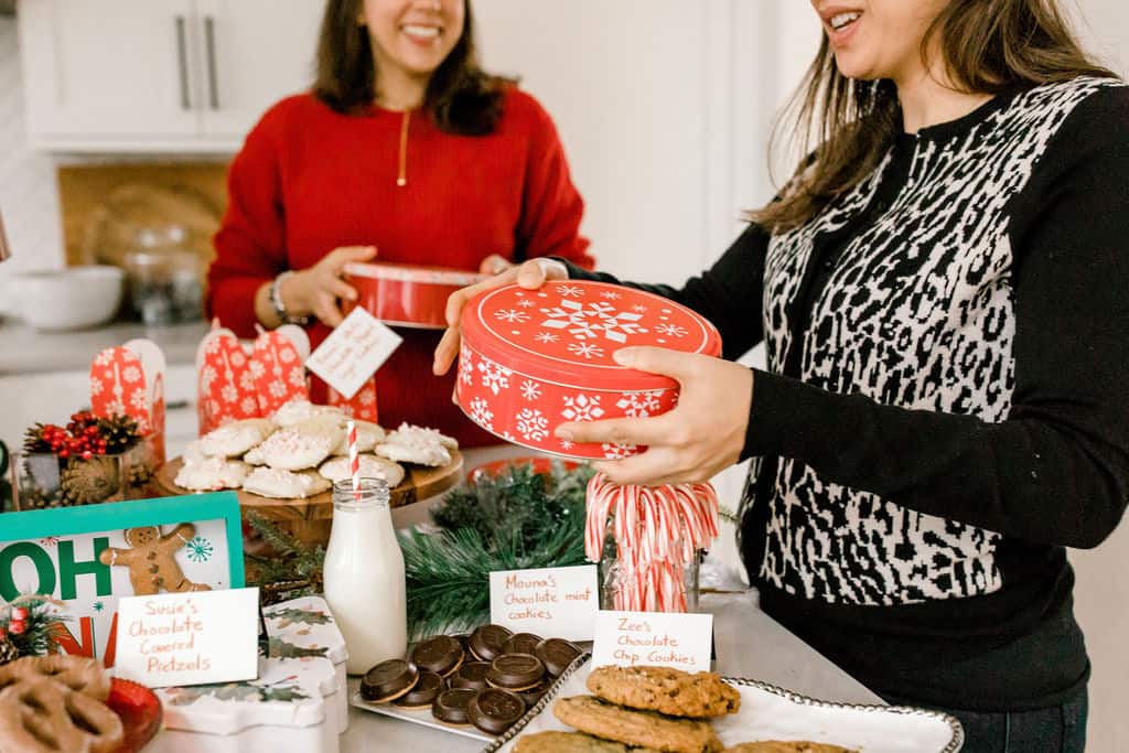 Holding box of cookies at cookie exchange party