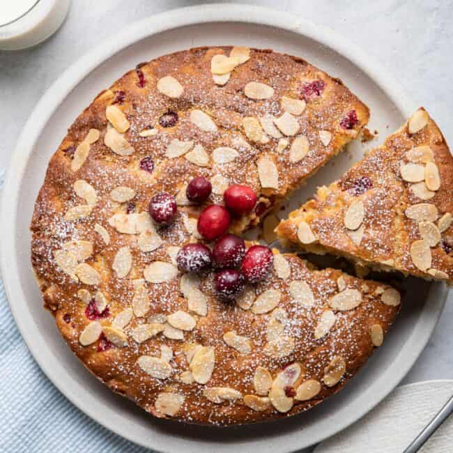 Cake with a slice cut out being lift away from plate.