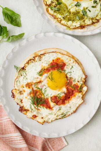 Crispy fried feta eggs with harissa on a tortilla shell garnished with fresh dill.