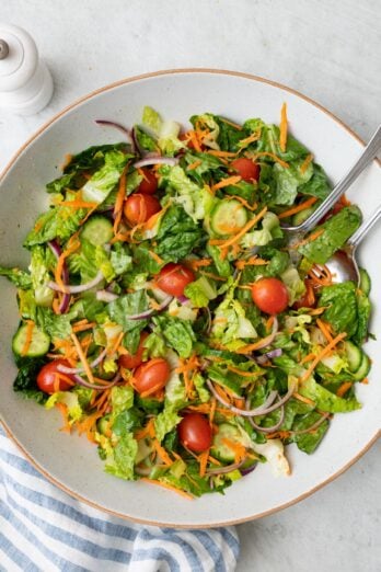 Everyday garden salad tossed with tomatoes, carrots, cucumbers, and shredded carrots.