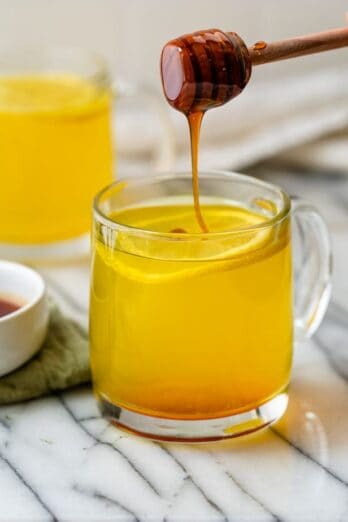 Honey being drizzled into Ginger Turmeric Tea