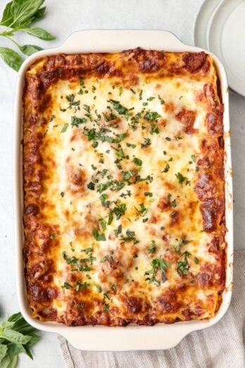 Greek Yogurt Lasagna in a baking dish garnished with fresh basil