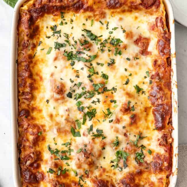 Greek Yogurt Lasagna in a baking dish garnished with fresh basil