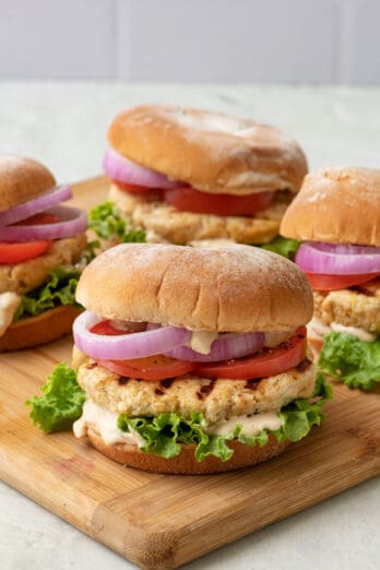 Grilled yogurt chicken burgers on a cutting board.