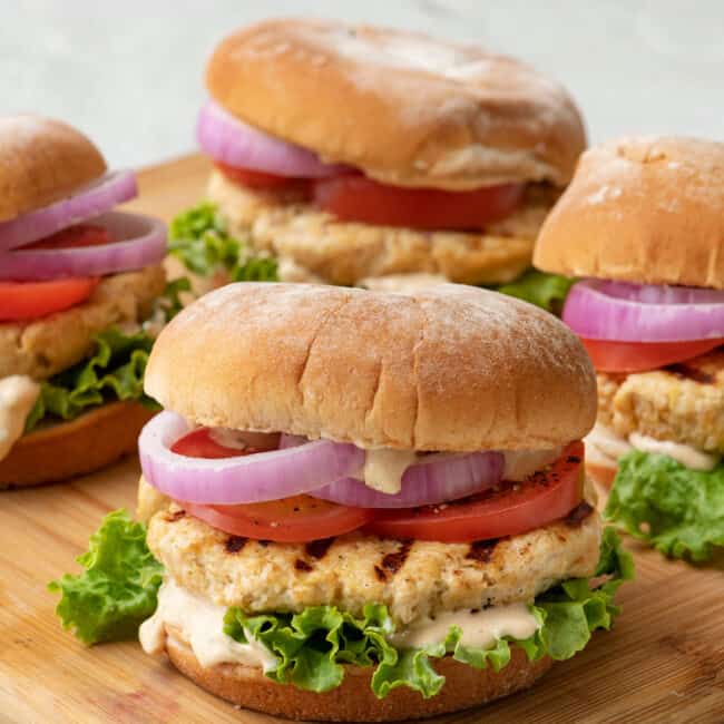 Grilled yogurt chicken burgers on a cutting board.