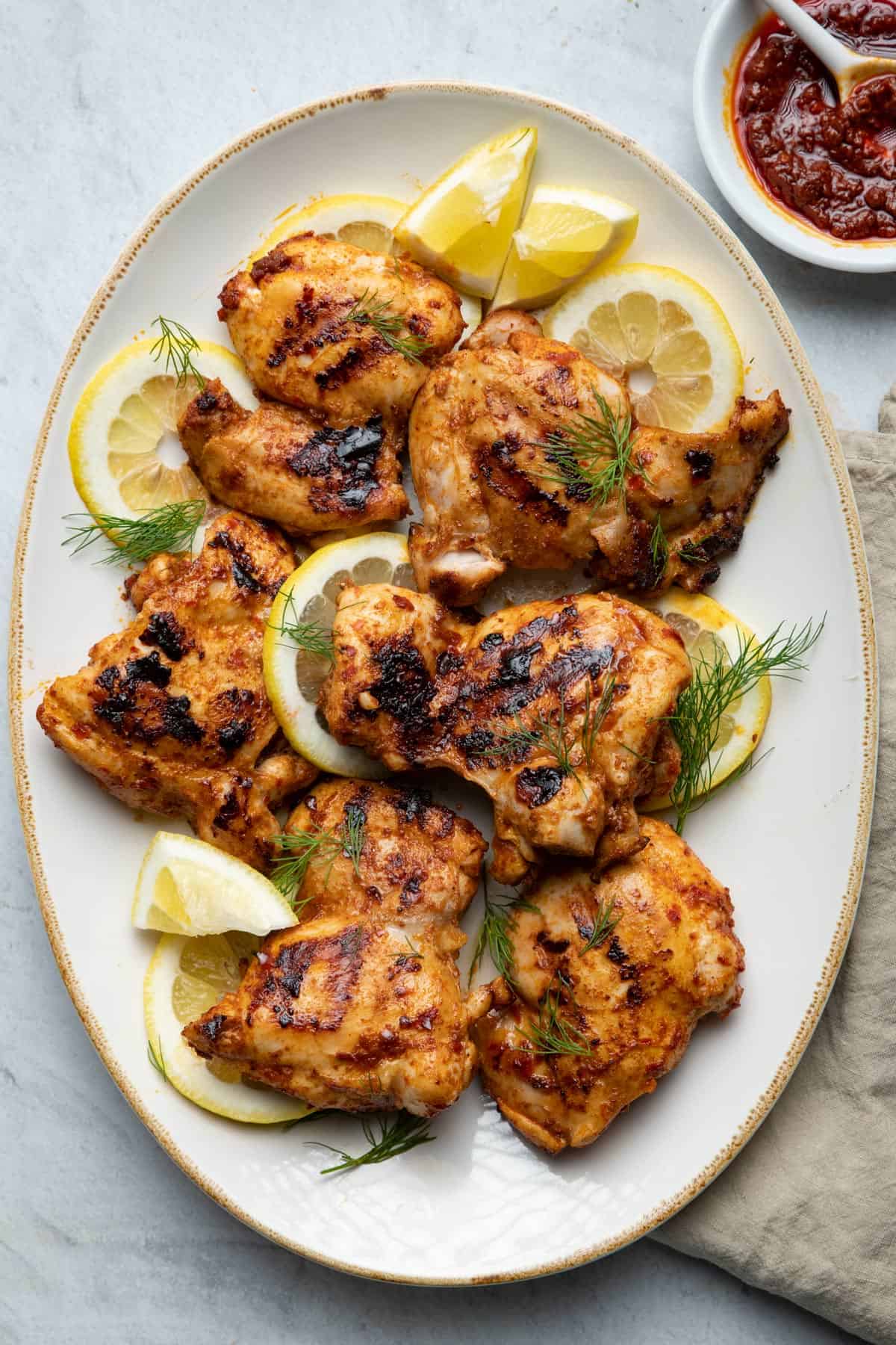 Grilled harissa on a platter served with lemon slices