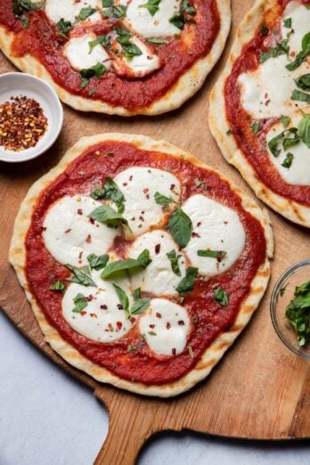 Close up of grilled pizzas on wooden cutting board