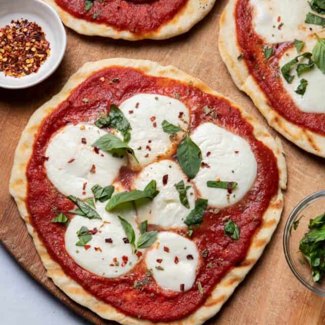 Close up of grilled pizzas on wooden cutting board