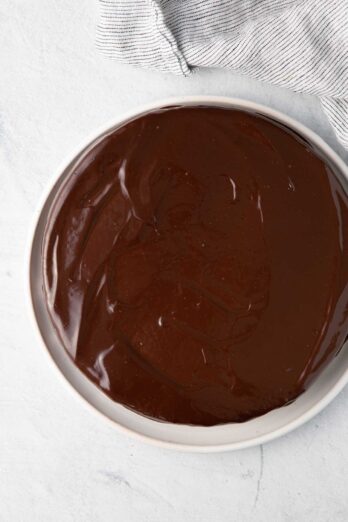 Ganache spread over round cake.