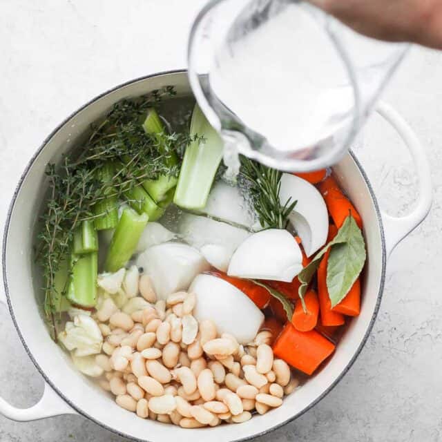 Dutch oven and pouring water on top of vegetables to make the stock