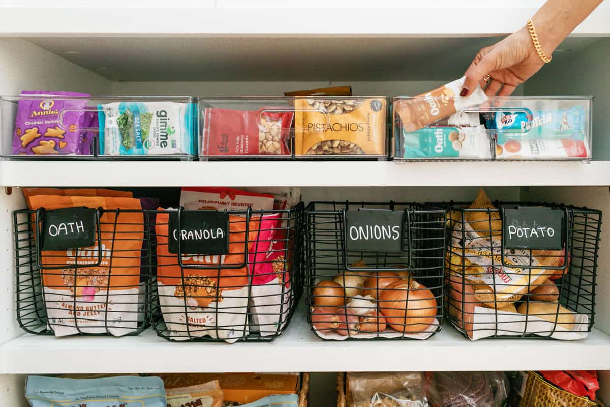 Two shelves in a pantry with quick grab snacks and produce.