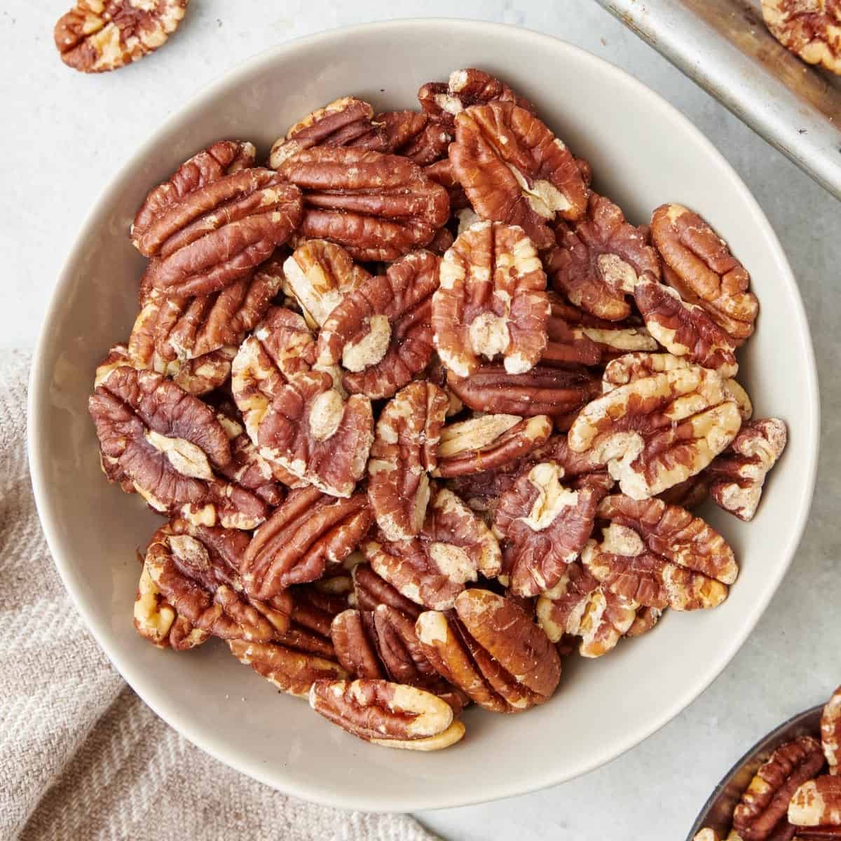 Square image of a bowl of toasted pecans.