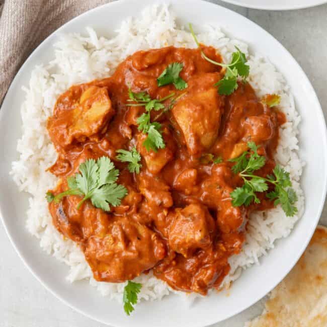 Instant pot butter chicken being lifted up with a ladle.