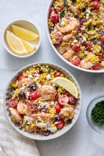 Large pan of the Mediterranean couscous with a small plate serving of the couscous next to it.