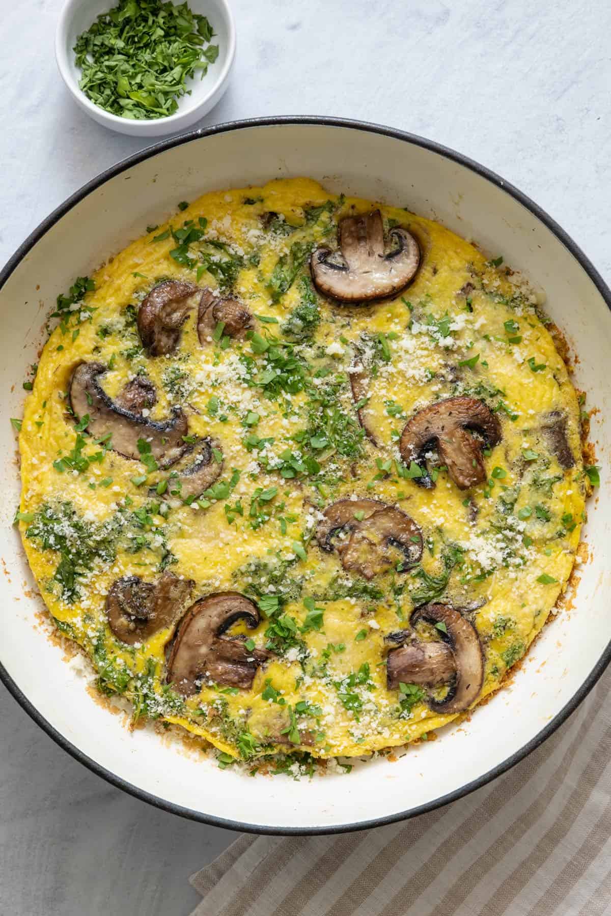 Overhead shot of baked recipe garnished with parmesan and parsely.