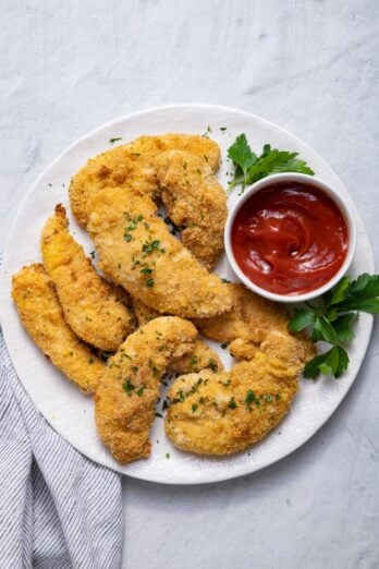 Oven Fried Chicken Tenders on a white plate served with ketchup