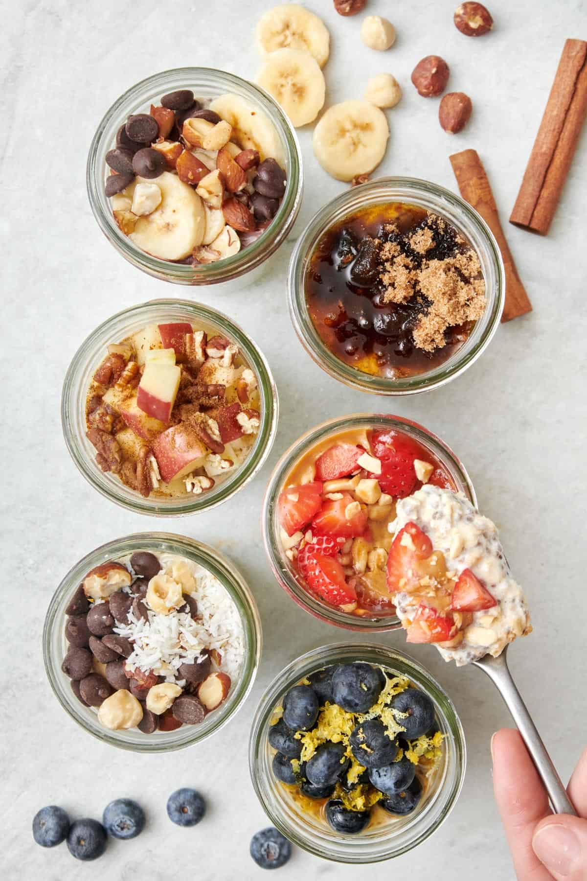 Almond joy overnight oats in a glass cup with other overnight oats in background