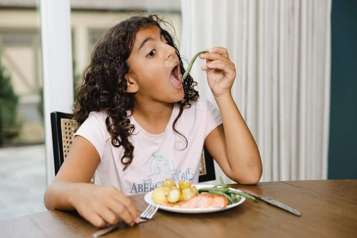 Carine taking bite out of green beans