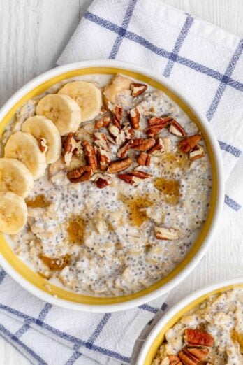 Sliced bananas on top of protein oatmeal in a large yellow bowl