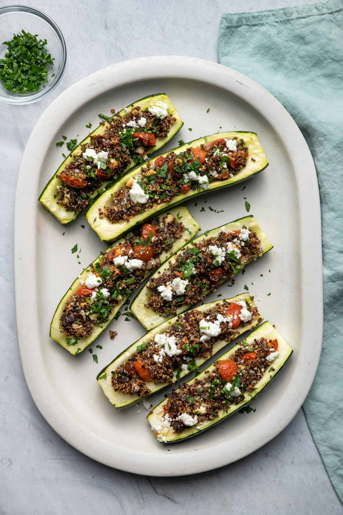 Top down shot of Quinoa Stuffed Zucchini boats on a large white plate