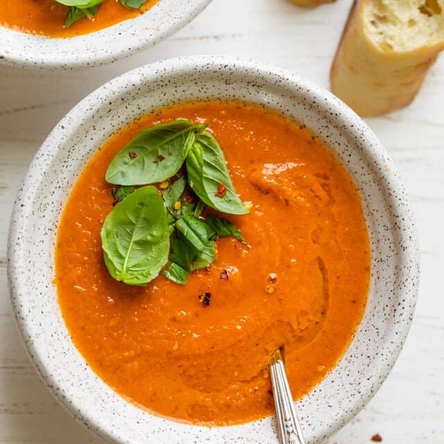 Final plated roasted tomato soup topped with fresh basil