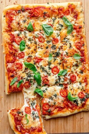 Sheet pan pizza with slice being pulled away