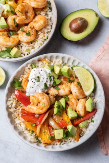 Two bowls of shrimp fajitas served over cilantro lime rice