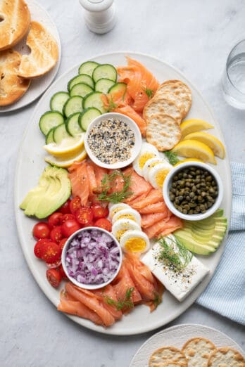 Smoked salmon platter with eggs, cucumber, avocado, tomatoes, crackers and more