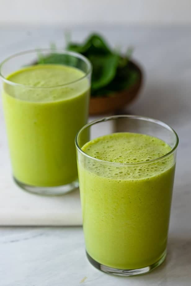 Superfood smoothies in two clear cups with bright green colors