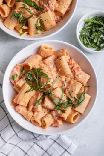 Overhead shot of two vegan creamy tomato pasta bowls