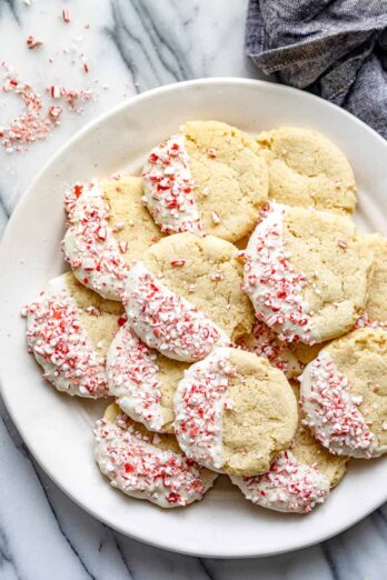 White plate on marble background of sugar cookies dipped in white chocolate