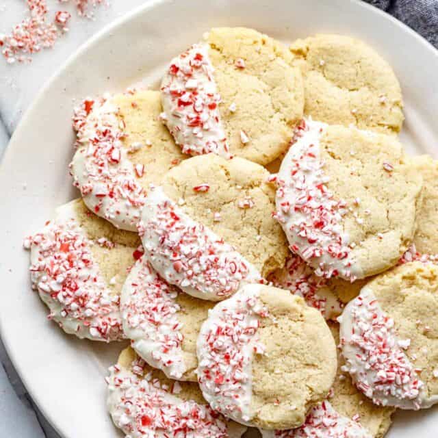 White plate on marble background of sugar cookies dipped in white chocolate