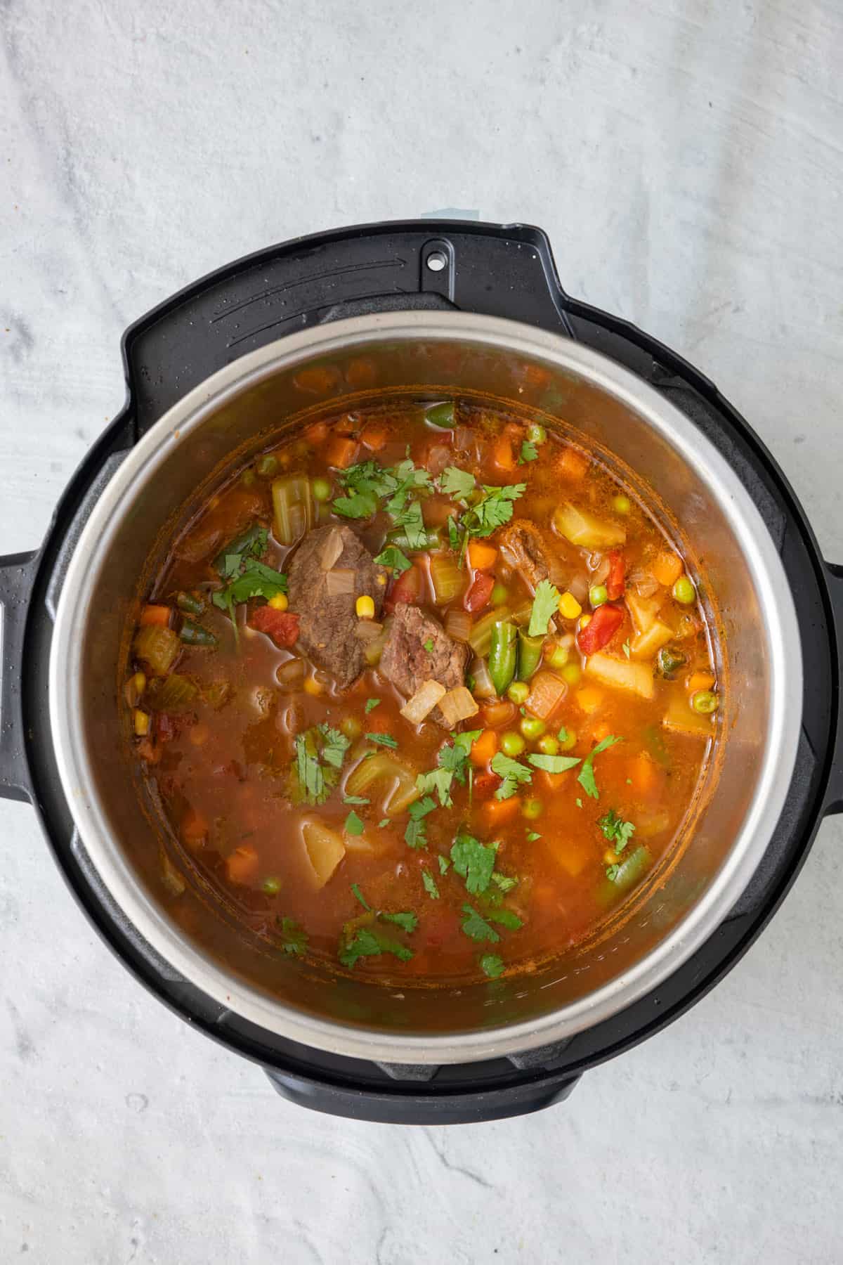 Soup in instant pot garnished with parsley.