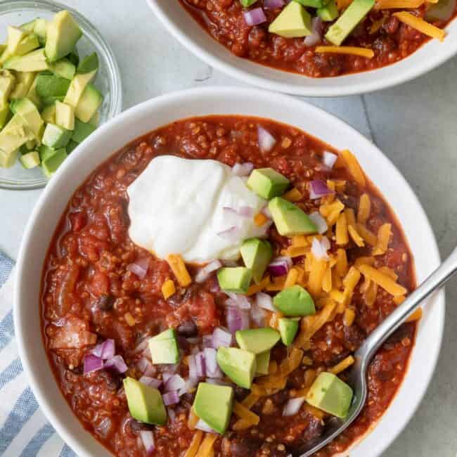 Overhead shot of chili in a white bowl with another filled bowl off to the side.